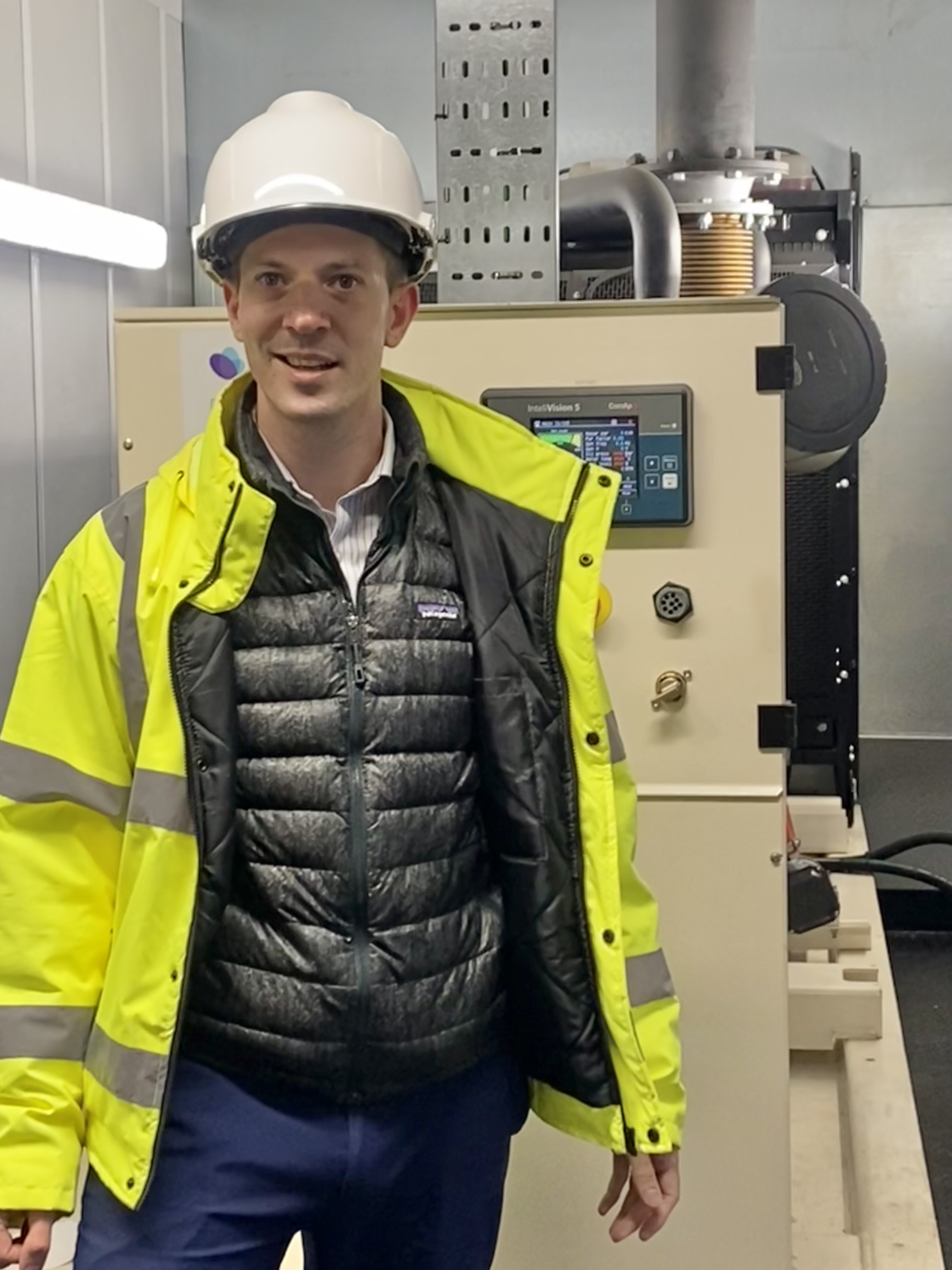 Photograph of Robert Hobkirk, Head of Sustainability Compliance and Risk at NHS Grampian, beside a back-up generator tank at the Foresterhill Health Campus.